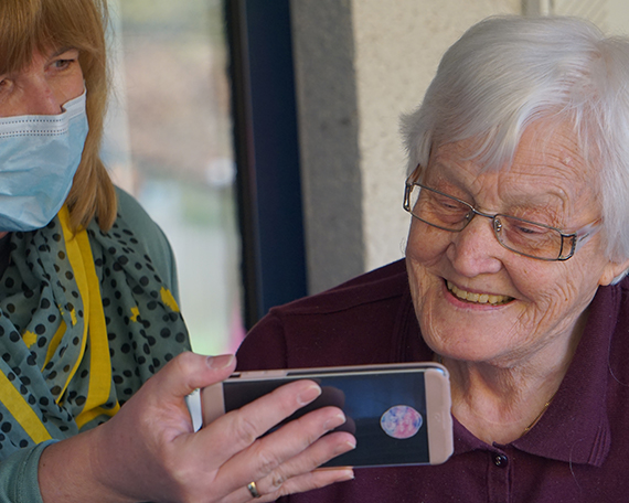 Resident and Staff Enjoying Picture on Phone
