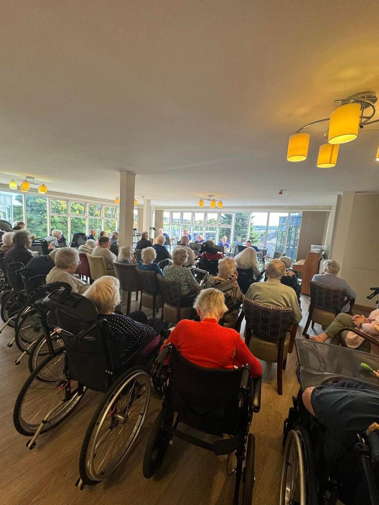 Deeside Care Home residents enjoying a music therapy session with The Plucking Pals.