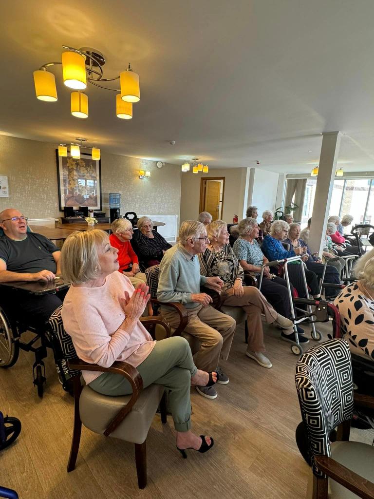 Deeside Care Home residents enjoying a music therapy session with The Plucking Pals.