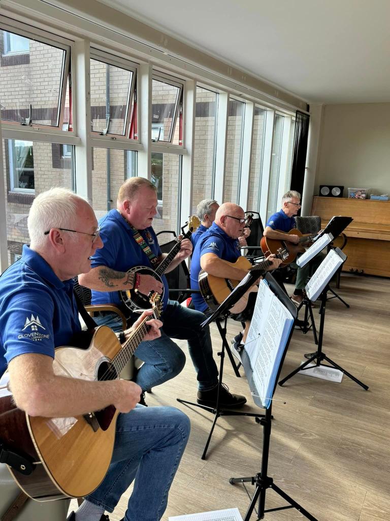 Deeside Care Home residents enjoying a music therapy session with The Plucking Pals.