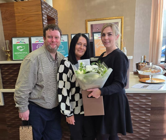 Deeside Home Manager and Deputies holding a bouquet of flowers