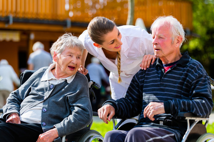 elderly people outside on a summers day with care home staff