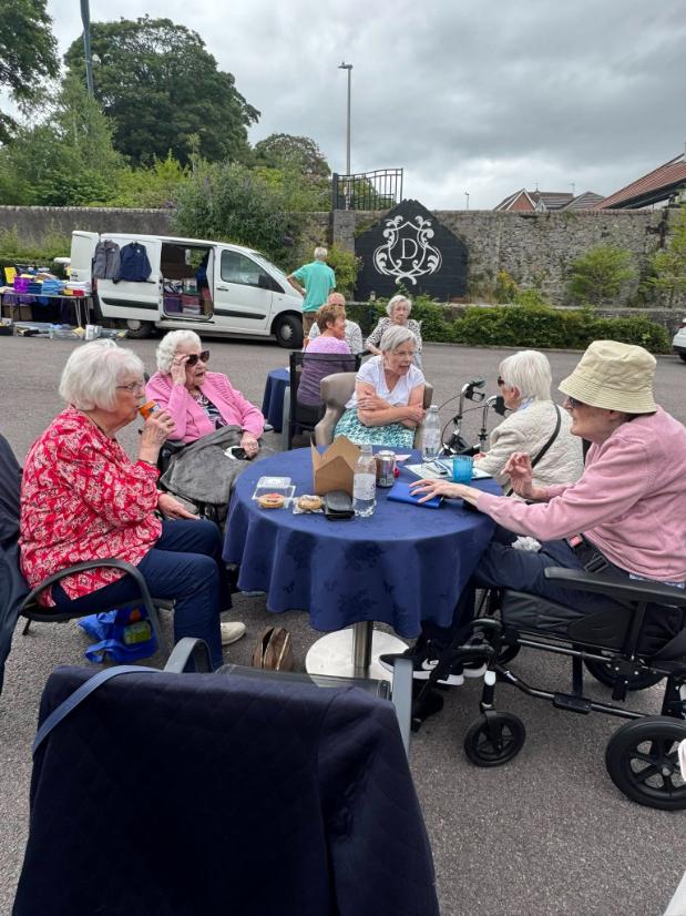 older people sat around a table outdoors
