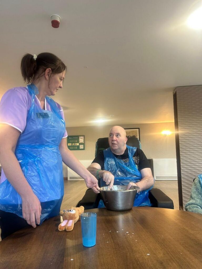 carer and a resident baking together