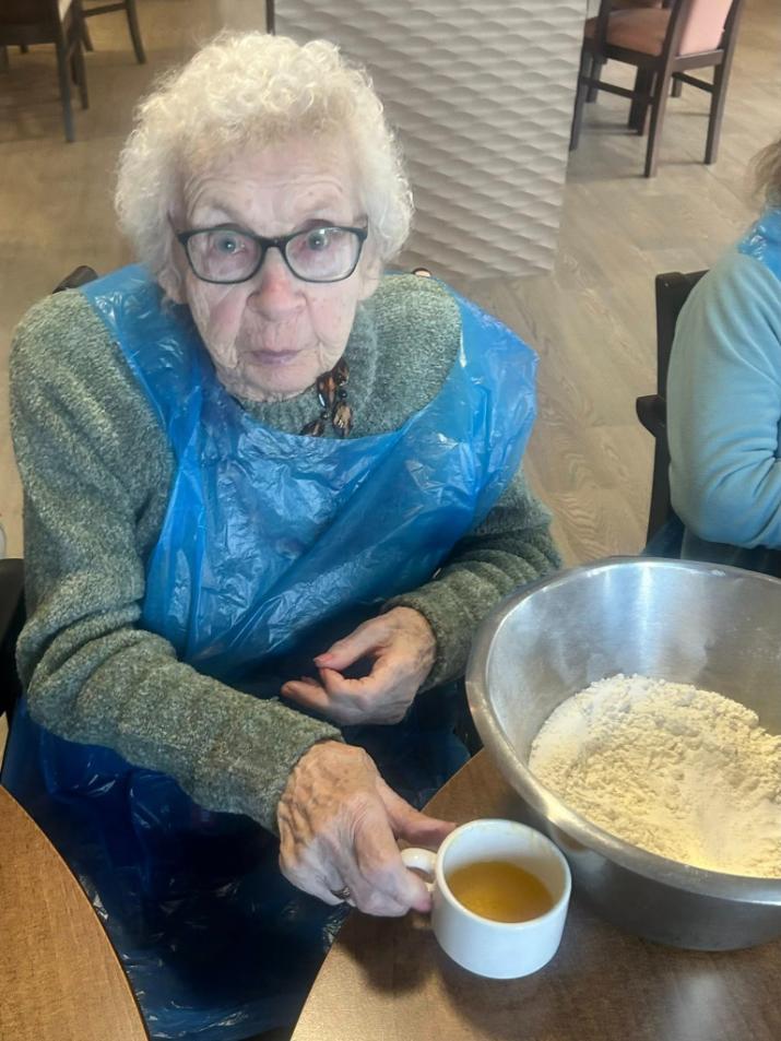 an older lady with a mixing bowl in front of her