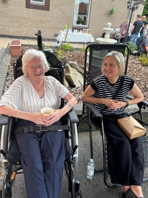 two older ladies sat down in a garden
